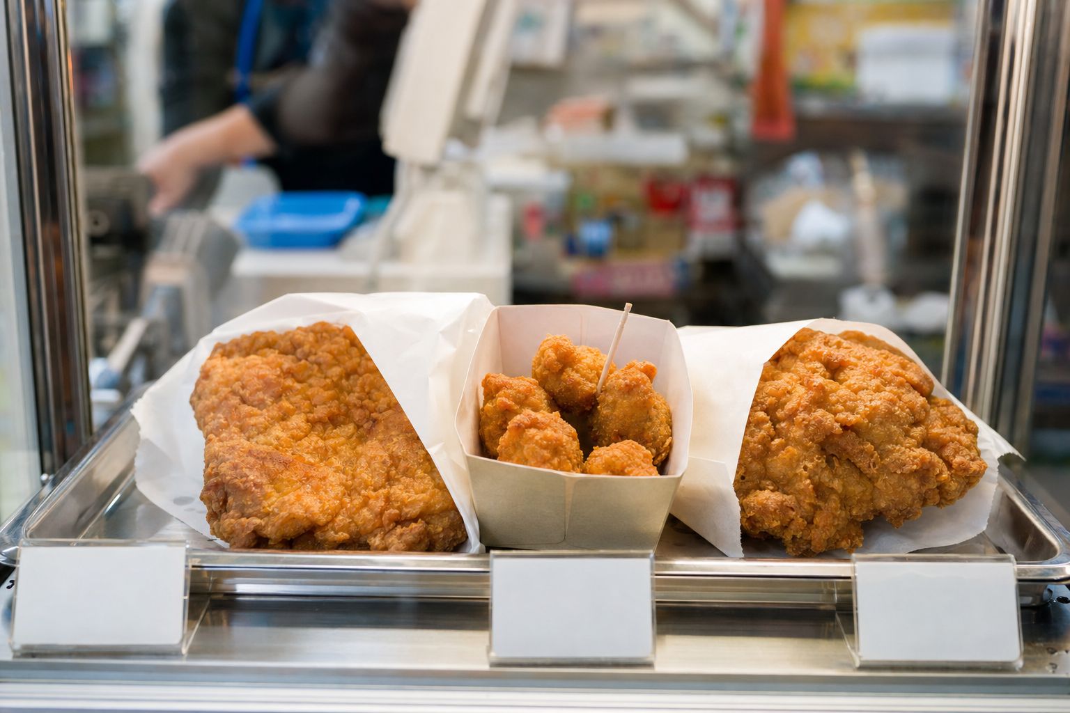 Three types of Japanese convenience store fried chicken displayed side by side under a heat lamp